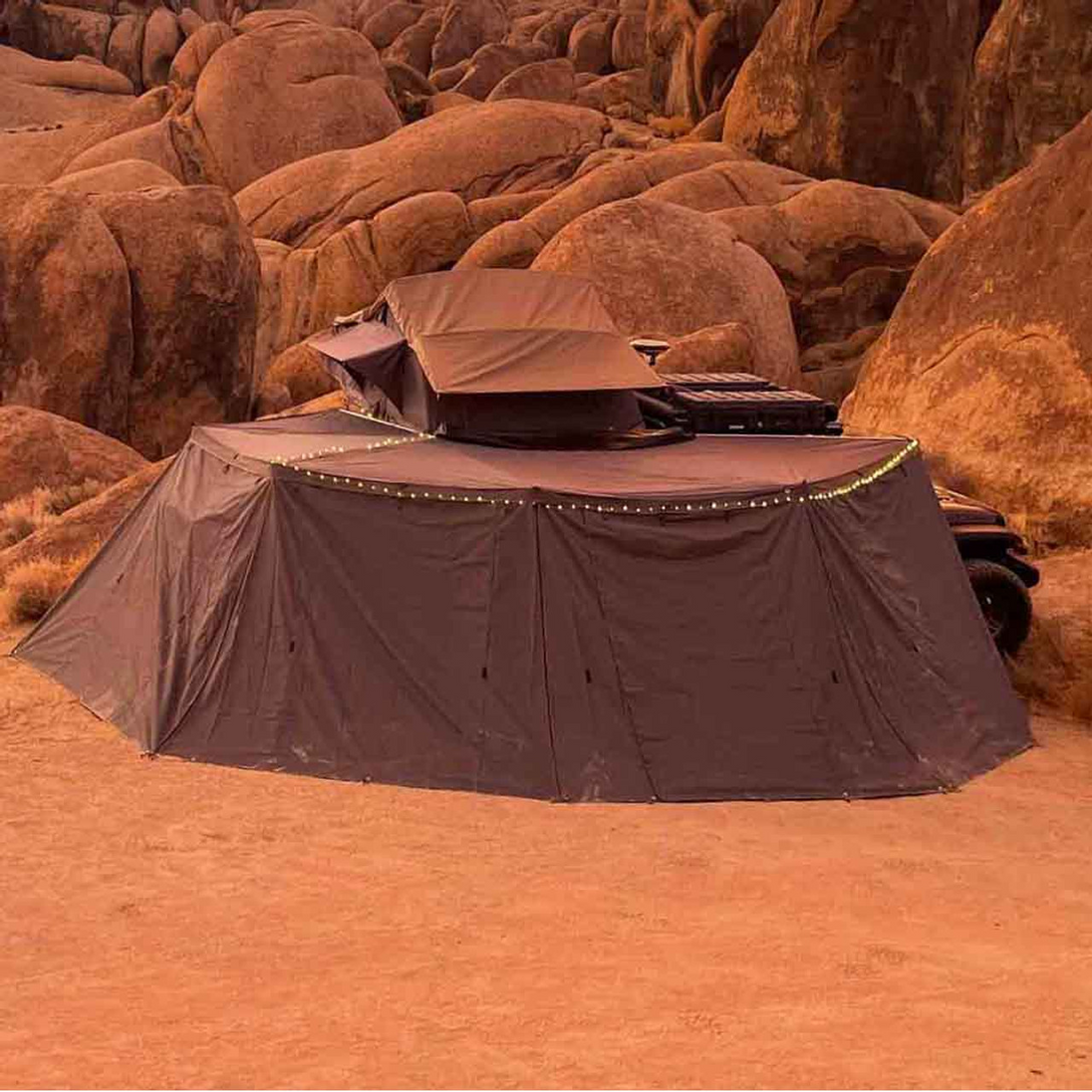 Overland Vehicle Systems Nomadic Awning Wall Kit attached to passenger-side vehicle awning creating enclosed shelter space
