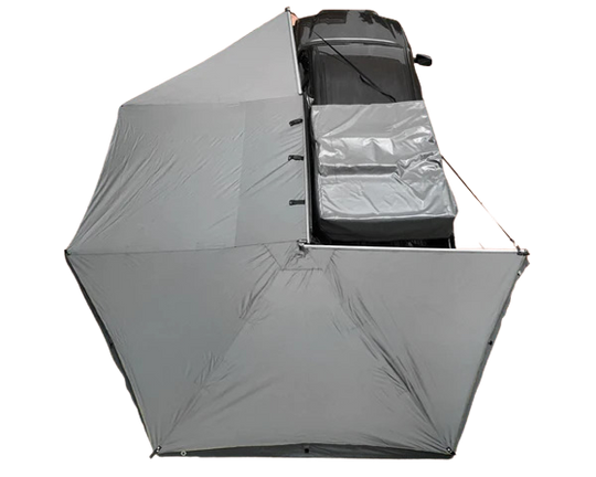 Black Overland Vehicle Systems Nomadic 270-degree awning extended from vehicle side providing shaded outdoor shelter