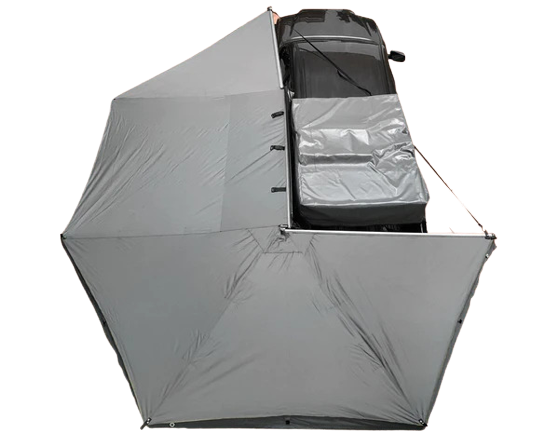 Black Overland Vehicle Systems Nomadic 270-degree awning extended from vehicle side providing shaded outdoor shelter