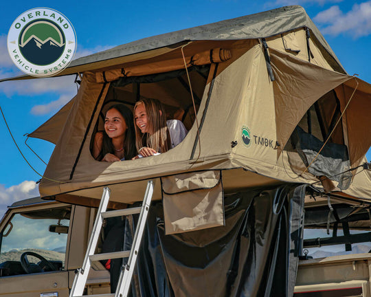 Overland Vehicle Systems TMBK rooftop tent mounted on vehicle roof with ladder extended and windows open