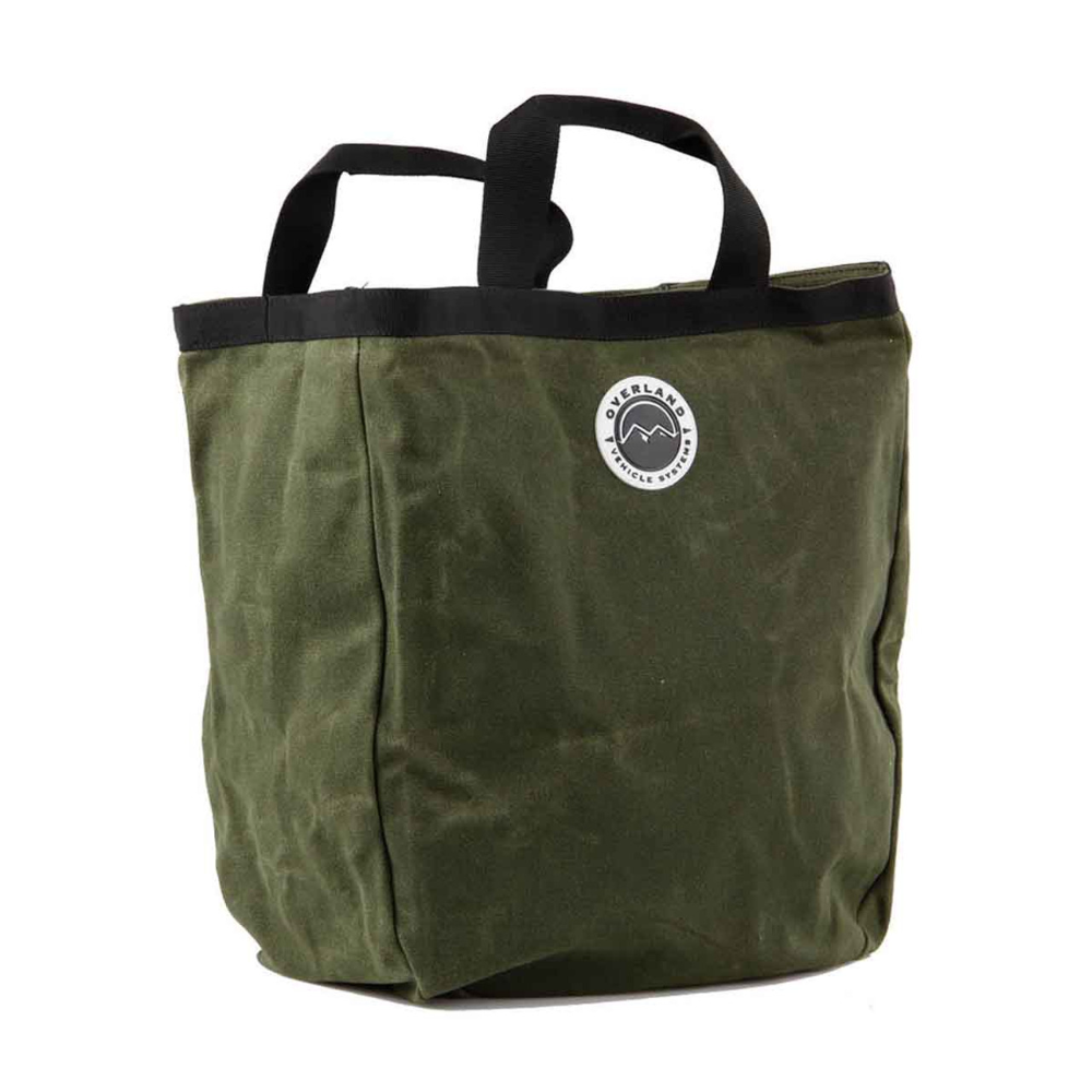 Overland Vehicle Systems waxed canvas tote bag with leather handles and metal hardware, shown in rugged outdoor setting