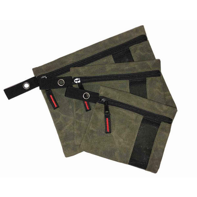 Set of three waxed canvas storage bags with leather handles and brass hardware on outdoor gear