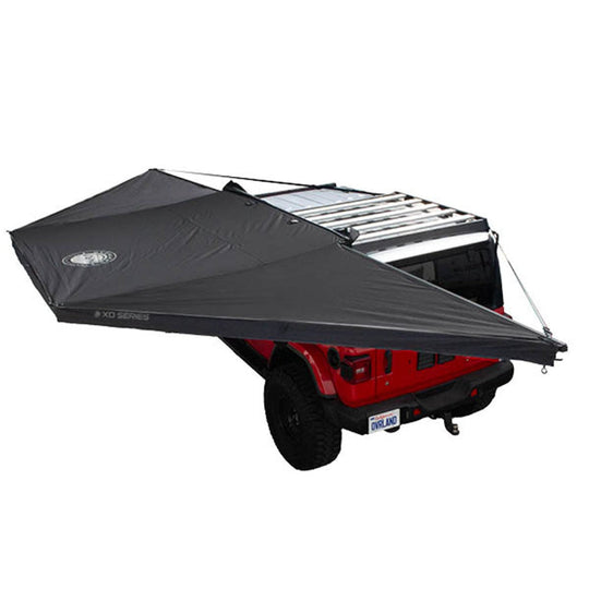 Black Overland Vehicle Systems Nomadic 180 Awning deployed with travel bag, showing freestanding shelter structure