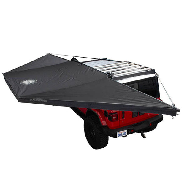 Black Overland Vehicle Systems Nomadic 180 Awning deployed with travel bag, showing freestanding shelter structure