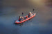 Two people in a red kayak on a calm body of water.