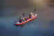 Two people in a red kayak on a calm body of water.