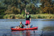Two people in a kayak on a calm lake with trees in the background