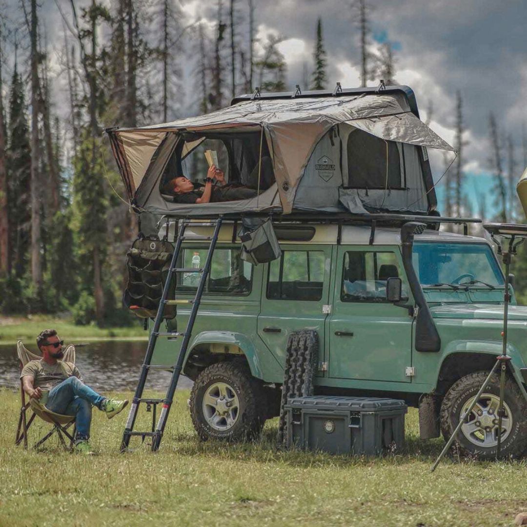 Overland Vehicle Systems Bushveld hard shell roof top tent mounted on vehicle rooftop with ladder extended
