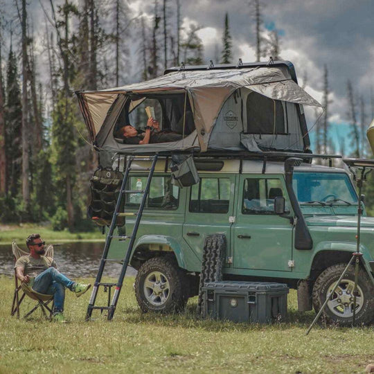 Overland Vehicle Systems Bushveld hard shell roof top tent mounted on vehicle rooftop with ladder extended