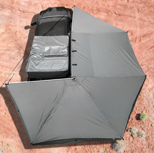 Overland Vehicle Systems Nomadic 270 awning deployed with side walls attached, creating a full shelter system around vehicle